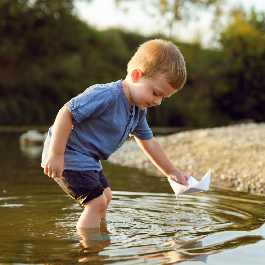 little boy with paper boat